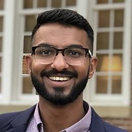 Person with glasses wearing suit jacket smiling 