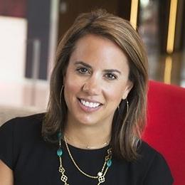 Person wearing black top sitting in red chair smiling